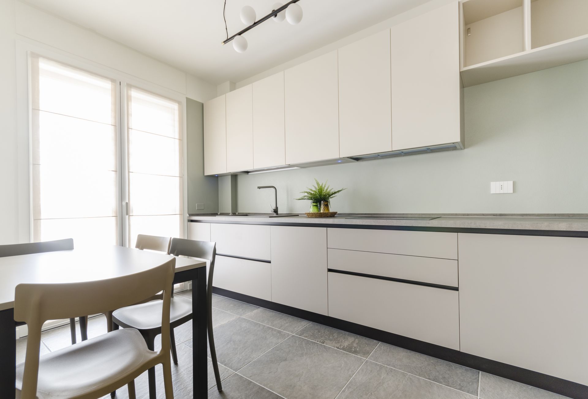 Una cucina moderna e funzionale con doppia colonna e tavolo da pranzo realizzato da Gilardi Interiors on Staging, Progettazione di interni a Melzo