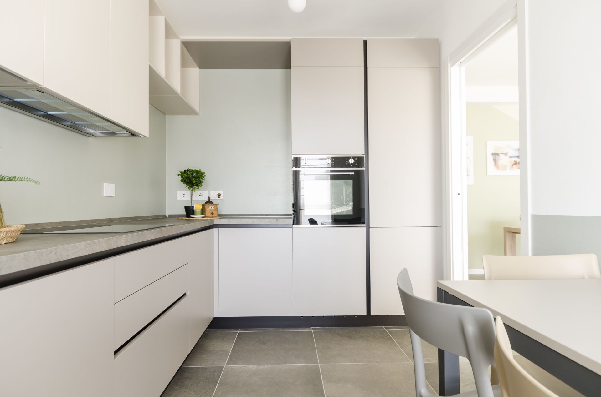 Una cucina moderna e funzionale con doppia colonna e tavolo da pranzo realizzato da Gilardi Interiors on Staging, Progettazione di interni a Melzo