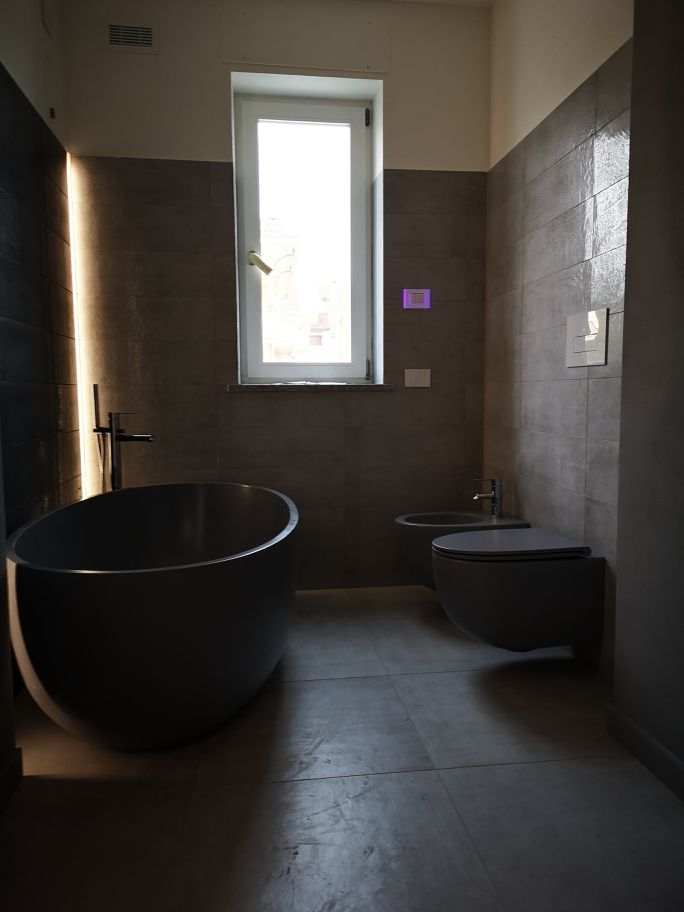 Bagno con vasca freestanding e giochi di luce realizzato da Gilardi Interiors on Staging, Progettazione di interni a Melzo